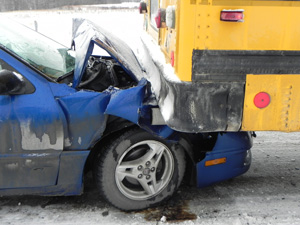 Passenger sedan rear-ends school bus